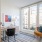 a room with a table chairs and a rug with a window and plants