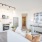 Model living room at our apartments for rent in Washington DC, featuring a white couch and view of the kitchen.