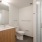 Model bathroom at our apartments for rent in Washington DC, featuring a shower with a glass door and wood cabinetry.